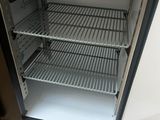 a small refrigerator with a door open on a wooden floor