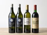 trois bouteilles de vin sont alignées sur une table en bois