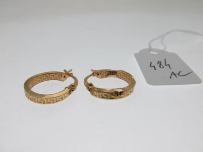 two gold rings with a price tag on a white surface