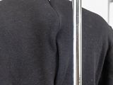 the back of a black jacket hanging on a metal pole