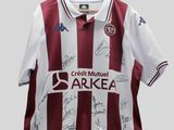 un gros plan sur un maillot de foot couvert de signatures