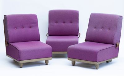 trois chaises violettes placées côte à côte sur une surface blanche