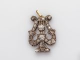 a close up of a gold and diamond pendant on a white surface