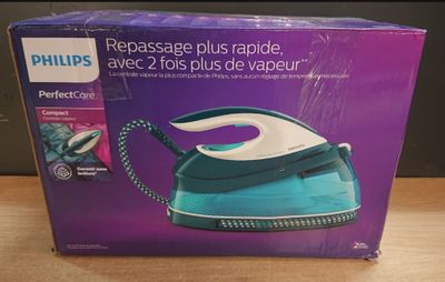 emballage d'un fer à repasser à vapeur bleu et blanc posé sur une table en bois