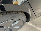 a close up of a tire on a car with a person standing next to it