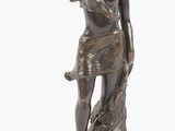 une image représentant une statue en bronze d'une femme debout sur un rocher