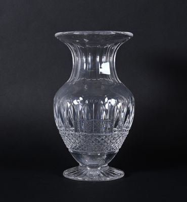 un vase en verre posé sur une surface noire