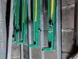 many green and yellow tools hanging on the wall