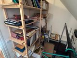 a book shelf with many books on it in the corner of a room