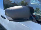 the side view mirror of a white van with a black trim