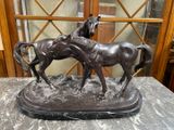 une statue représentant deux chevaux debout sur une table