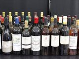 Des bouteilles de vin sont alignées sur une table devant un fond noir.