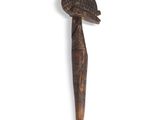 a wooden stick with a bird on it on a white surface
