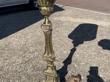 a gold candle holder on the side of the road