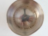 a silver bowl with a small object inside of it