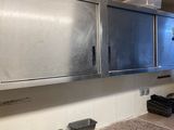 une cuisine avec des placards en inox et des plans de travail en granit