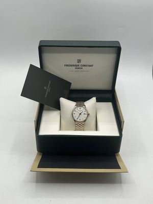 l'image d'une montre dans une boîte sur une surface blanche