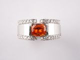 une bague avec une pierre orange entourée de diamants blancs