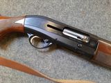 the rifle is laying on the floor next to the strap