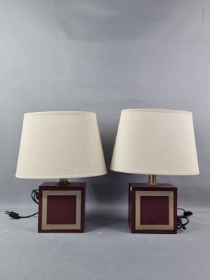 une paire de lampes de table rouges et dorées avec des abat-jours blancs