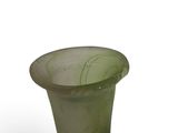 a green vase that is sitting on a white surface