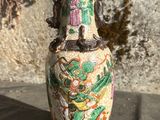 un vase posé sur une table près d'un mur