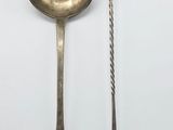two spoons and a spoon rest on a white surface