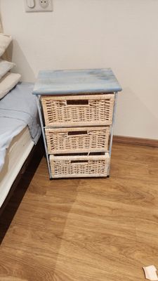 hardwood flooring in a bedroom with a bed and a wicker chest of drawers