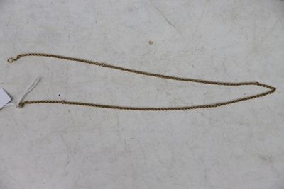 une chaîne en or qui a été coupée et qui gît par terre