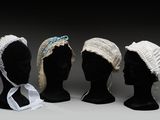 trois têtes de mannequins sont alignées en rang, coiffées de chapeaux