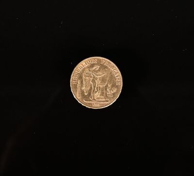 une pièce d'or posée sur une surface noire, sur fond noir