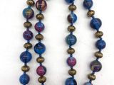 un collier de perles bleues et violettes sur un fond blanc