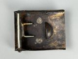 an old metal buckle with a metal handle on a white surface
