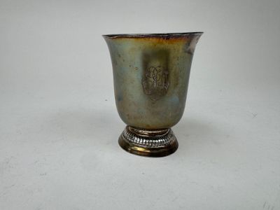 une coupe en argent posée sur une table blanche