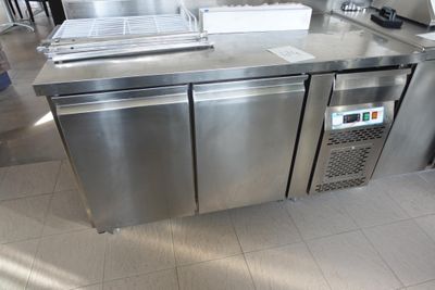 un plan de travail en inox sur lequel sont posés tout un tas de plats