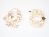 deux rangs de perles blanches et un fermoir en or sur fond blanc