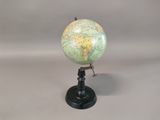 a small globe that is on a stand on a table