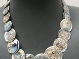Le collier est composé de perles en nacre et en argent.