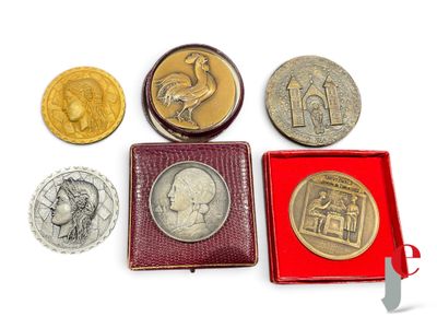 quatre types de pièces différents dans une boîte rouge posée sur une surface blanche
