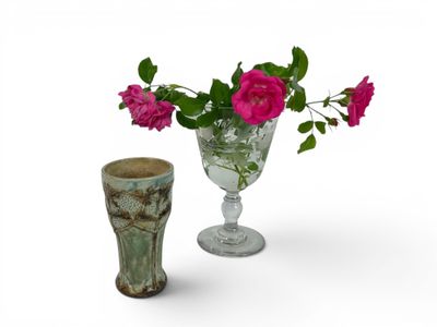 two vases with flowers in them on a white surface