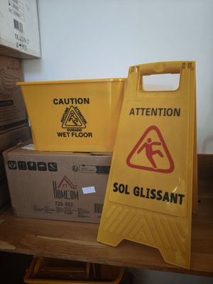 yellow caution sign sitting on top of a wooden table next to boxes