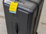 un bagage posé par terre, avec une étiquette de prix accrochée dessus