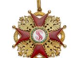 un gros plan d'une médaille rouge et or sur fond blanc