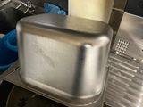 a silver toaster sitting on top of a metal pan