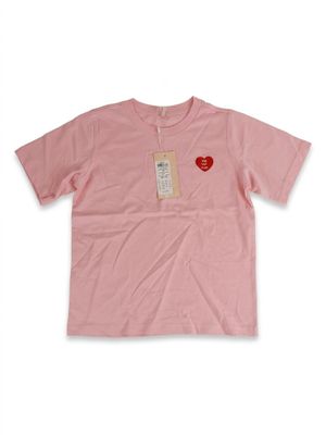 une chemise rose avec un cœur sur le devant et une étiquette dans le dos
