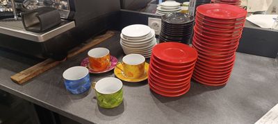 de nombreuses assiettes et tasses posées sur le plan de travail de la cuisine