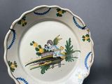 two plates with birds and flowers painted on them on a gray surface