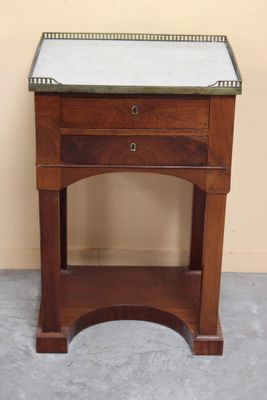 a small wooden table with a marble top on it