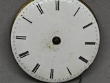 une horloge blanche avec des chiffres romains noirs