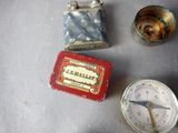 a lighter, a lighter case, and a pocket watch sitting on a table
